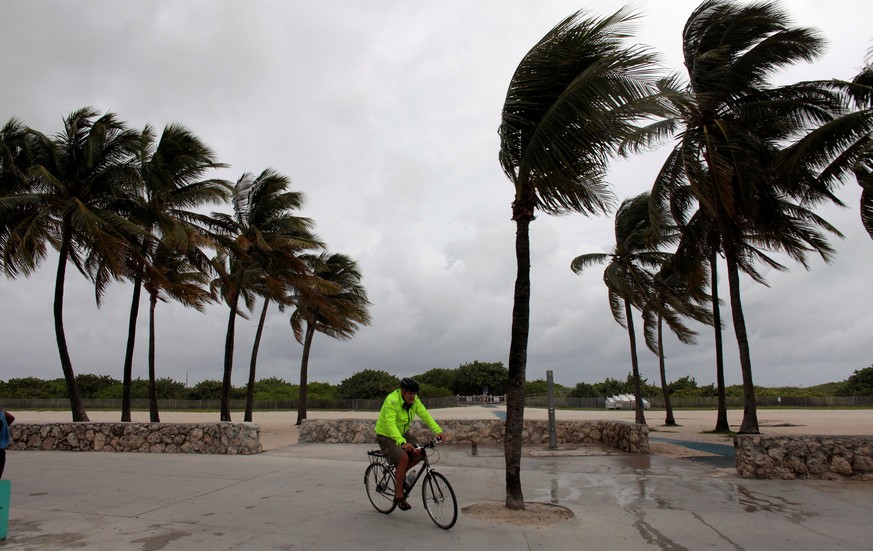 A man rides his bicycle along the beach prior to the arrival of Hurricane Matthew in Miami Beach, Florida, U.S. October 6, 2016. REUTERS/Javier Galeano