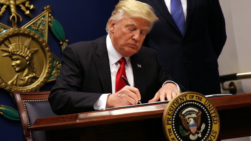 U.S. President Donald Trump signs an executive order to impose tighter vetting of travelers entering the United States, at the Pentagon in Washington, U.S., January 27, 2017. The executive order signe ...