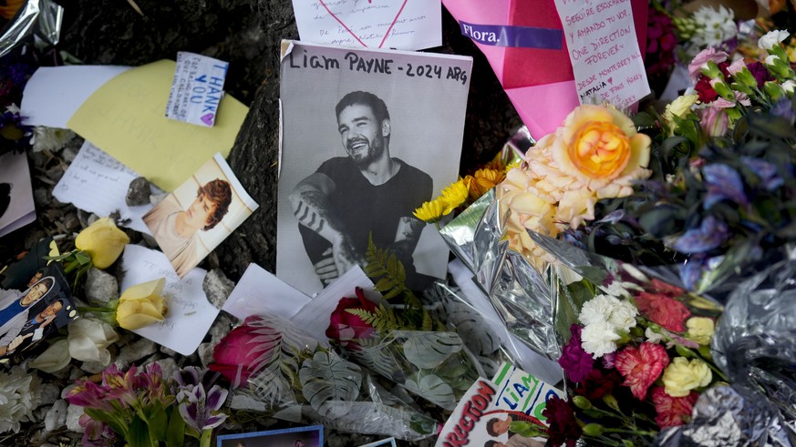Nachrichten Linkding FILE - A picture of former One Direction singer Liam Payne sits surrounded by flowers and candles as fans gather outside the hotel where he was found dead after falling from a balcony in Buenos Aires, ...