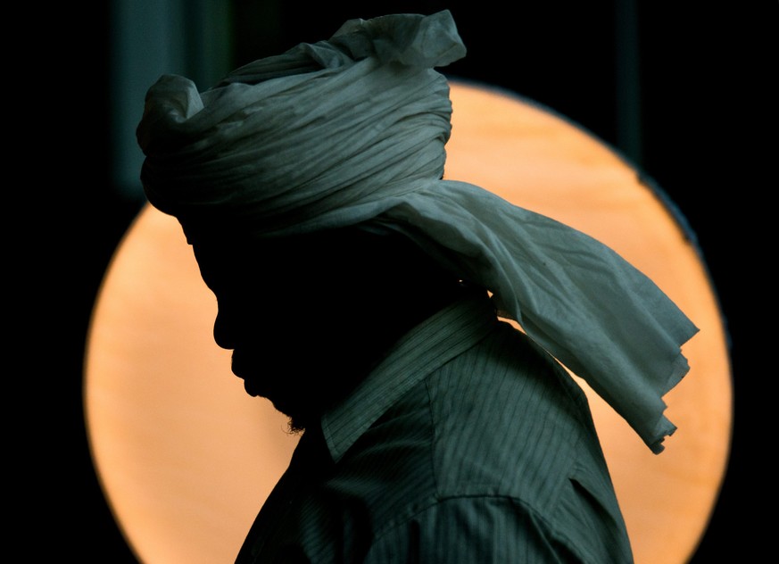 epa04880768 A refugee stands in front of a flash head in the Hannover Messe Hall 21, in Hannover, Germany, 12 August 2015. All incoming refugees are to be photographed. The Hall 21 has been set up for ...