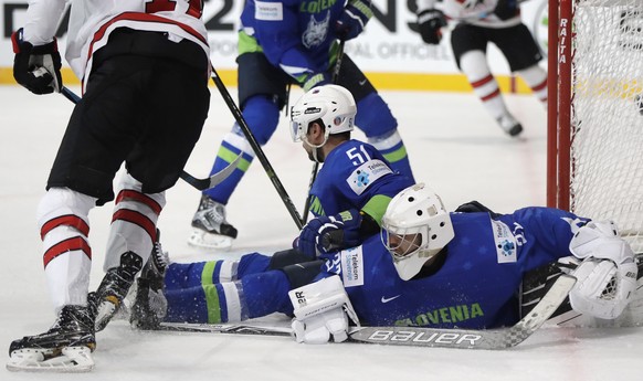 Slovenia&#039;s Gasper Kroselj, right, and Slovenia&#039;s Mitja Robar, center, make a save against Canada&#039;s Wayne Simmonds, left, during the Ice Hockey World Championships group B match between  ...