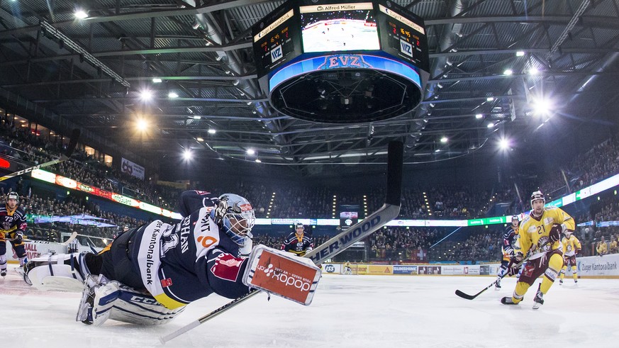 Zugs Torhueter Tobias Stephan, links, kaempft um den Puck gegen Servettes Tim Traber, rechts, im ersten Eishockey Playoff-Viertelfinalspiel der National League A zwischen dem EV Zug und dem Geneve-Ser ...