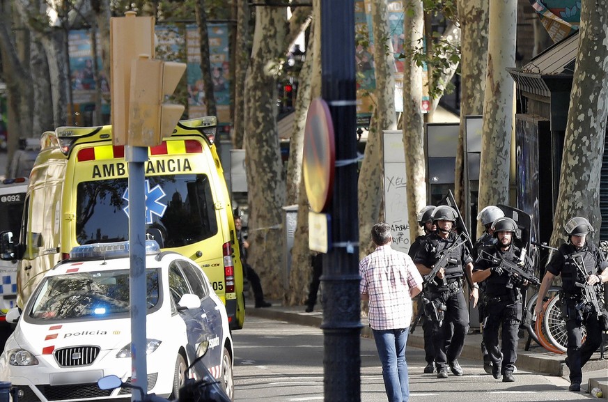 epa06148715 Heavily armed police officers arrive for a manhunt near the site where a van crashes into pedestrians in Las Ramblas, downtown Barcelona, Spain, 17 August 2017. According to initial report ...
