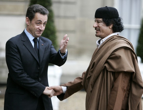 French President Nicolas Sarkozy, left, greets Libyan leader Col. Moammar Gadhafi upon his arrival at the Elysee Palace, in Paris, Monday, Dec. 10, 2007. Gadhafi takes a giant stride toward internatio ...