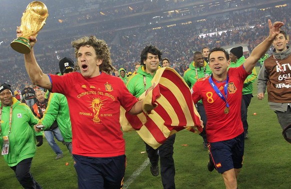 Spain&#039;s Carles Puyol, left, and Xavi celebrate with the trophy after winning the 2010 FIFA soccer World Cup final between the Netherlands and Spain in the Soccer City Stadium in Johannesburg, Sou ...