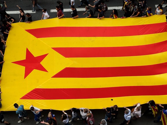 epa06242146 People march holding a Catalan pro-independence flag through Via Laietana in Barcelona, northeastern Spain, 03 October 2017, to protest against the police actions during a general strike i ...