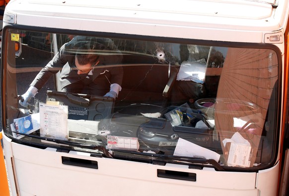An investigator is seen inside a gas cylinder delivery truck with bullet holes in its windscreen after police fired shots to stop the driver, whom they say had stolen the truck and was driving against ...