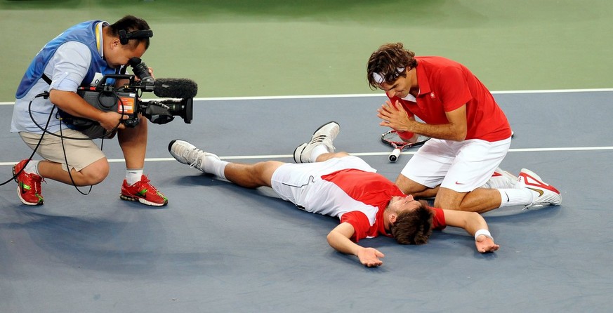 epa01450818 Stanislas Wawrinka of Switzerland (L) and teammate Roger Federer (R) celebrate their gold medal win during their finals match against Swedish pair Simon Aspelin and Thomas Johansson at the ...