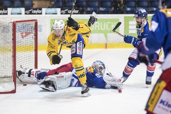 Der Davoser Chris Egli, oben, fliegt mit dem Puck zum 3:2 Tor gegen Goalie Luca Boltshauser, unten, von Kloten waehrend dem Eishockey-Meisterschaftsspiel der National League zwischen den EHC Kloten un ...