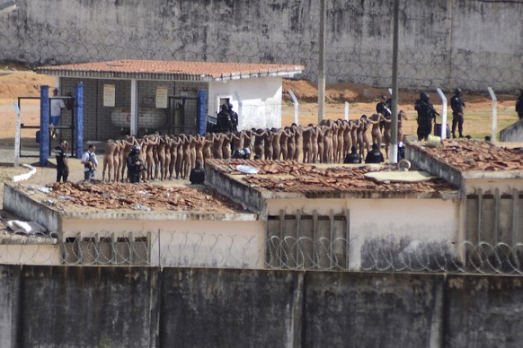 Naked inmates stand in line while surrounded by police after a riot at the Alcacuz prison in Nisia Floresta, Rio Grande do Norte state, Brazil, Sunday, Jan. 15, 2017. Security authorities said Sunday  ...