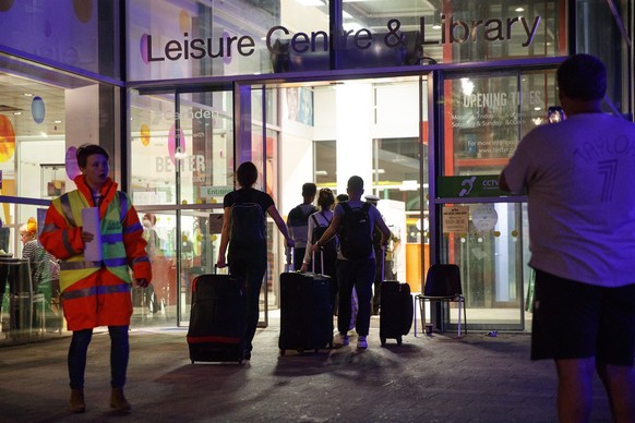 epaselect epa06046676 Residents evacuated from Chalcots Estate tower blocks arrive at Swiss Cottage Leisure Centre and Library in Camden, London, Britain, 23 June 2017, preparing to spend the night in ...