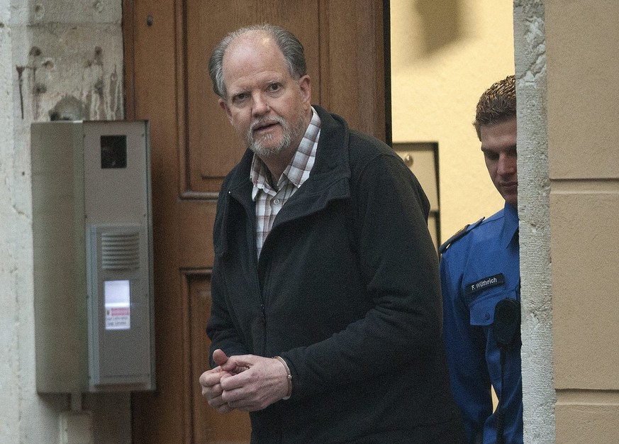 JAHRESRUECKBLICK 2013 - JANUAR - A gauche Peter-Hans Kneubuehl, menotte, suivi d&#039;un policier, se rendant dans la salle du tribunal d&#039;arrondissement de Biel, Bienne, ce lundi 7 janvier 2013.  ...