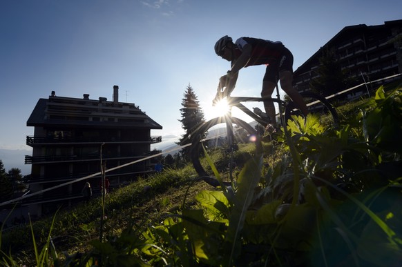 A biker rides down a mountain pasture in Nendaz, during the 25th Swiss Mountain Bike Marathon &quot;Grand Raid&quot; from Verbier to Grimentz, Southwestern Switzerland, Saturday, August 23, 2014. More ...
