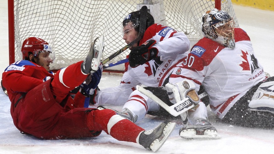 Team Canada&#039;s Drew Doughty and Russia&#039;s Oleg Saprykin slide into the net past Canada goaltender Dwayne Roloson during the first period of the gold medal game at the IIHF Men&#039;s World Hoc ...