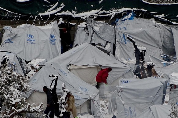 epa05703850 Snow covers tents at the Moria refugees camp on the island of Lesbos, after heavy snowfalls, on 07 January 2017. A cold wave across Greece causing temperatures to drop drastically brought  ...