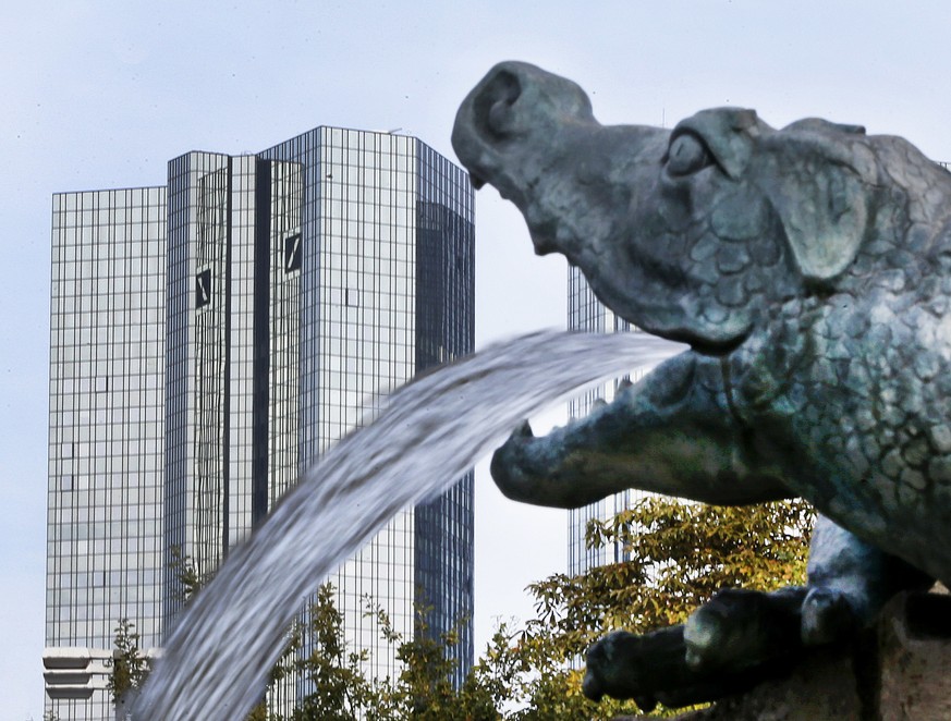 FILE - In this Oct. 11, 2016 file photo, water spills out of a small dragon sculpture on a fountain with the headquarters of the Deutsche Bank in background in Frankfurt, Germany, Germany&#039;s strug ...