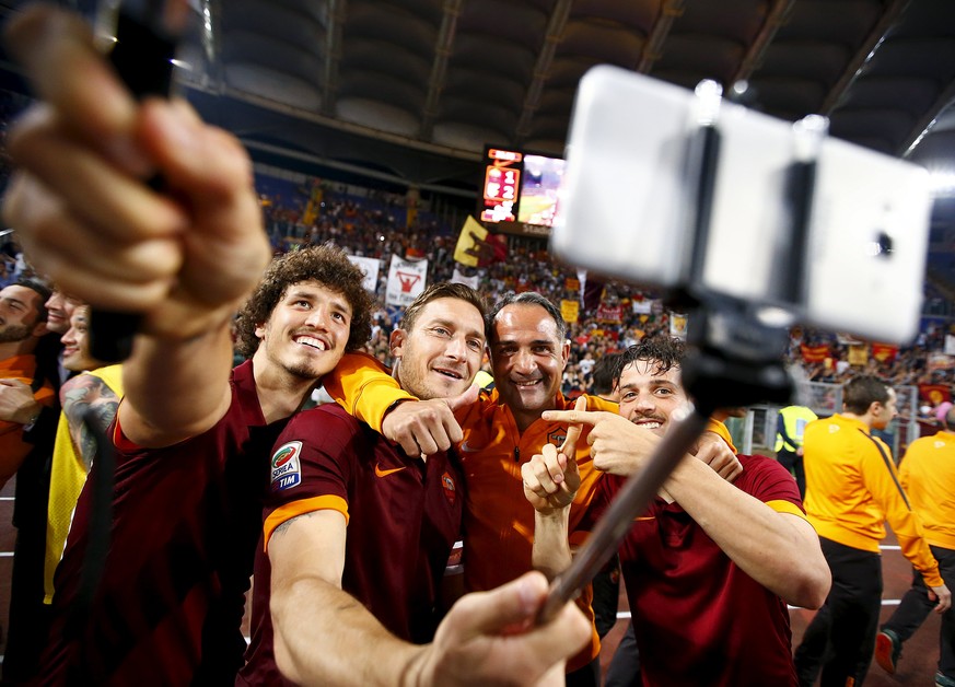 AS Roma&#039;s Francesco Totti (2nd L) takes a selfie with his team mates Alessandro Florenzi (R) and Salih Ucan (L) at the end of their Italian Serie A soccer match against Palermo at the Olympic sta ...
