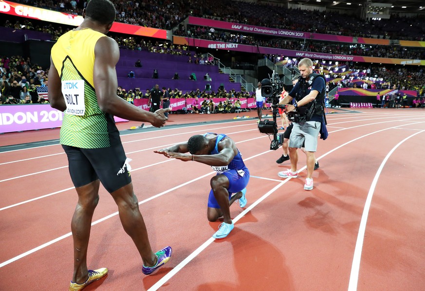 epa06127320 Justin Gatlin kneels in front of Usain Bolt of Jamaica after the men&#039;s 100m final at the London 2017 IAAF World Championships in London, Britain, 05 August 2017. Gatlin won gold, Bolt ...