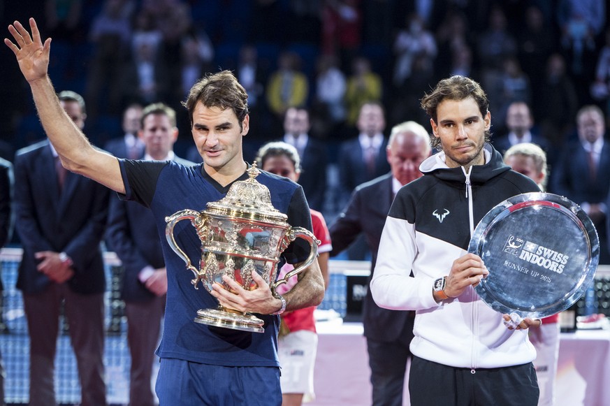 Switzerland&#039;s Roger Federer, left, reacts with the trophy, next to Spain&#039;s Rafael Nadal, right, after their final match at the Swiss Indoors tennis tournament at the St. Jakobshalle in Basel ...