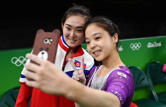 FILE PHOTO - 2016 Rio Olympics - Gymnastics training - Rio Olympic Arena - Rio de Janeiro, Brazil - 04/08/2016. Lee Eun-Ju (KOR) of South Korea (R) takes a selfie picture with Hong Un Jong (PRK) of No ...