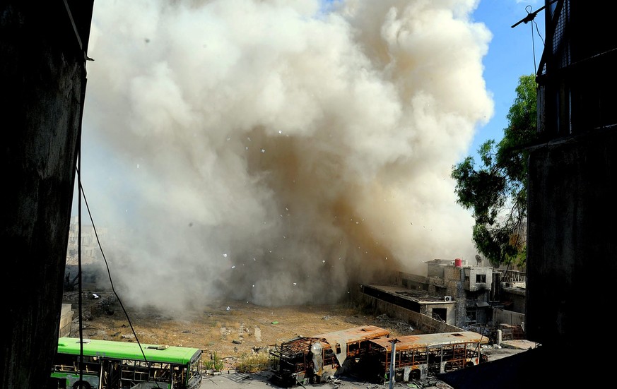 epa04297786 A handout picture made available on 04 July 2014 by Syrian Arab news agency (SANA) shows smoke and dust rising from an explosion during demolition of tunnels in Jouber area in rural Damasc ...