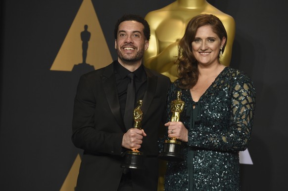 Ezra Edelman, left, and Caroline Waterlow pose in the press room at the Oscars on Sunday, Feb. 26, 2017, at the Dolby Theatre in Los Angeles. (Photo by Jordan Strauss/Invision/AP)