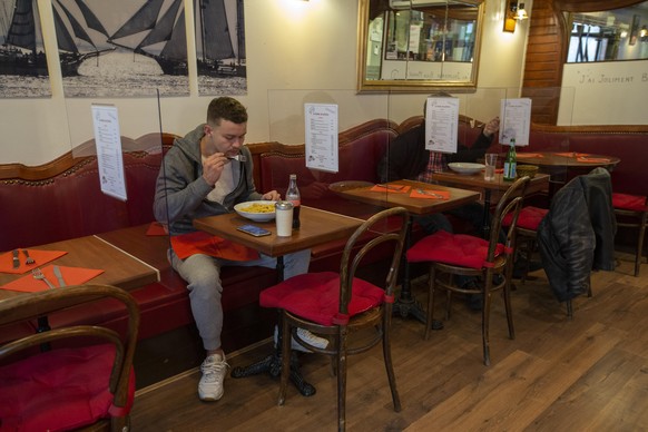 Customers eat on tables that its are separated with plexiglas as a preventive measure against the spread the coronavirus COVID-19 at the restaurant Le Radar de Poche, in Geneva, Switzerland, Wednesday ...