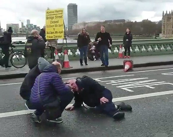 epa05863659 A video grabbed still image, made available by former Polish foreign minister Radoslav Sikorski, showing people attending to an injured person at the Westminster Bridge, near the Houses of ...