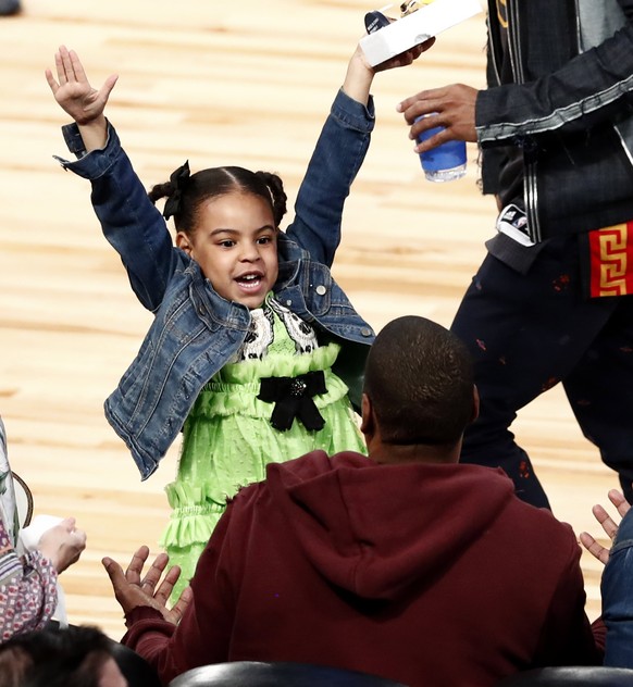 epa05804808 Blue Ivy Carter (L), daughter of Jay-Z and Beyonce reacts with her father Jay-Z (R) during the NBA All-Star Game at the Smoothie King Center in New Orleans, Louisiana, USA, 19 February 201 ...