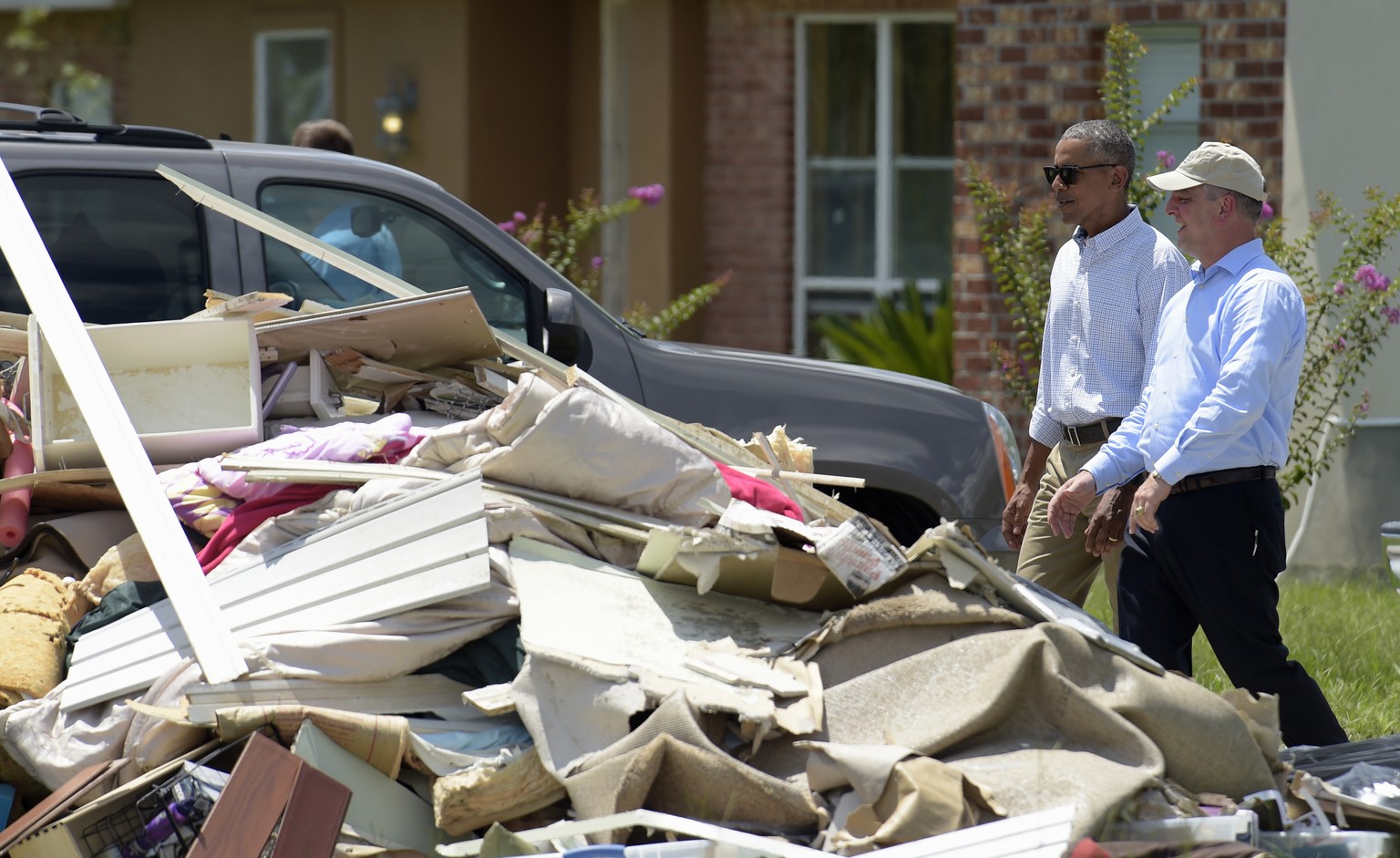 President Barack Obama and Louisiana Gov. John Bel Edwards tour Castle Place, a flood-damaged area of Baton Rouge, La., Tuesday, Aug. 23, 2016. Obama is making his first visit to flood-ravaged souther ...