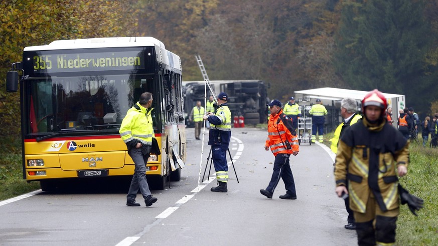 Police and rescue workers stand near a passenger bus and a truck after an early morning collision, which also involved a car, near Endingen, northwest of Zurich November 11, 2014. The exact number of  ...