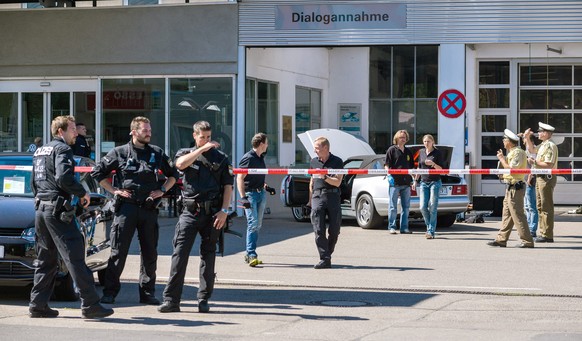 epa04841011 Policeman stand by the suspected perpetrator&#039;s vehicle (rear) at a gas station in Bad Windsheim, Germany, 10 July 2015. Two people were dead 10 July after a man allegedly began shooti ...