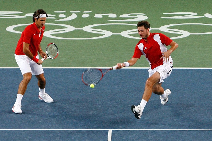 Roger Federer, left, and Stanislas Wawrinka of Switzerland play their gold medal match against Sweden&#039;s Simon Aspelin and Thomas Johansson at the Beijing Olympic Green Tennis Central Court for th ...