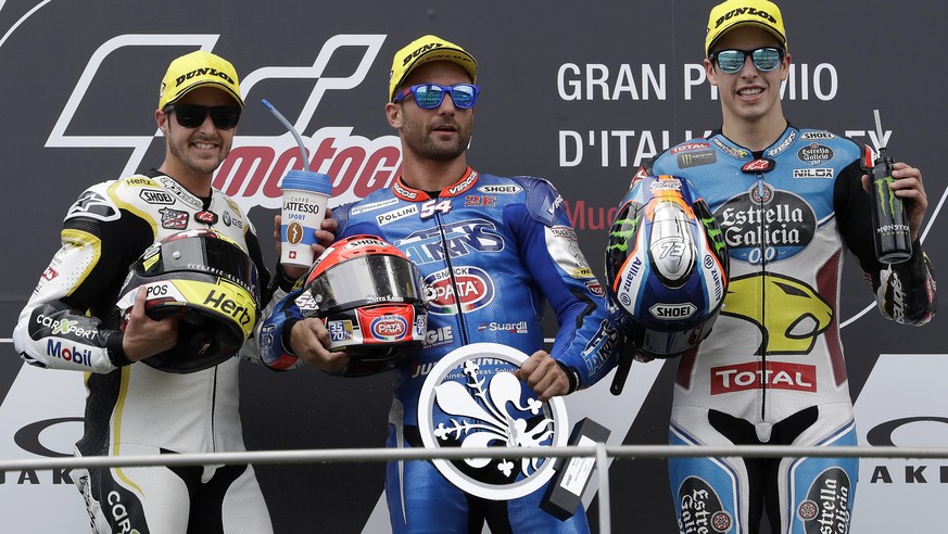 Kalex rider Mattia Pasini, center, of Italy, winner of the Italy Moto 2 grand prix, celebrates on the podium with second placed Kalex rider Thomas Luthi, left, of Switzerland, and third placed Kalex r ...