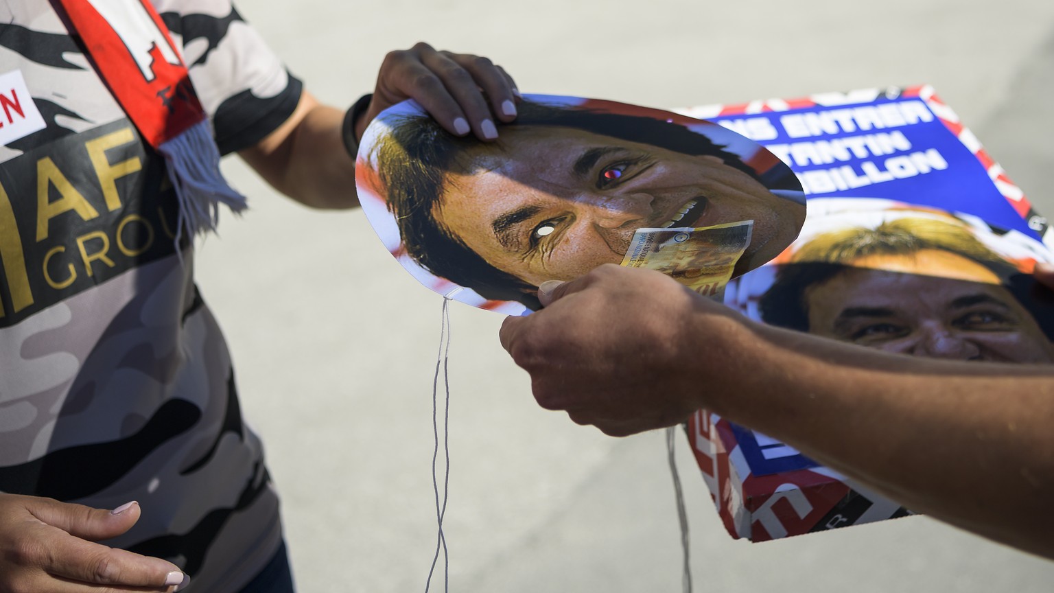 Une personne vend des masques en carton avec le portrait du president du FC Sion Christian Constantin, lors de la rencontre de football de Super League entre le FC Sion et le FC St. Gallen ce dimanche ...