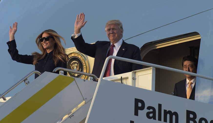 President Donald Trump, center, and first lady Melania Trump, left, wave from the top of the steps of Air Force One at Palm Beach International Airport in West Palm Beach, Fla., Friday, Feb. 10, 2017, ...