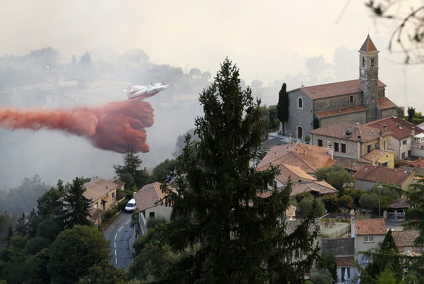 epa06093308 A firefighting aircraft attends to the scene of a forest fire in the town of Castagniers near Nice, southern France, 17 July 2017. Large forest fires fueled by strong winds and dry weather ...