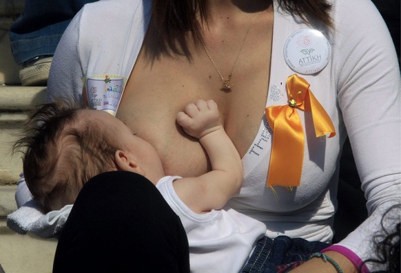 epa03934699 A woman breastfeeds her baby during a public breastfeeding for the celebration of Breastfeeding Week in Athens, Greece, 03 November 2013. Mothers breastfed their babies in the 4th Panhelle ...