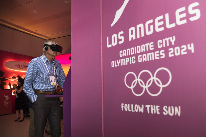 epa06082739 A journalist is pictured with a virtual reality mask in the show room of Los Angeles 2024 during the presentation of Los Angeles 2024 Candidate City Briefing for International Olympic Comm ...