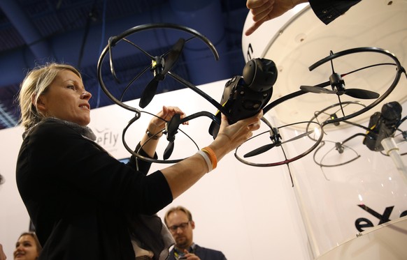 Andrea Halter holds up an Exom senseFly drone at the Parrot booth during the International CES Tuesday, Jan. 6, 2015, in Las Vegas. (AP Photo/John Locher)