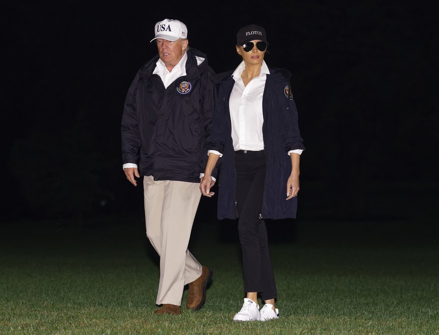 President Donald Trump and first lady Melania Trump walk from Marine One across the South Lawn to the White House in Washington, Tuesday, Aug. 29, 2017, as they return from Austin, Texas. (AP Photo/Ca ...