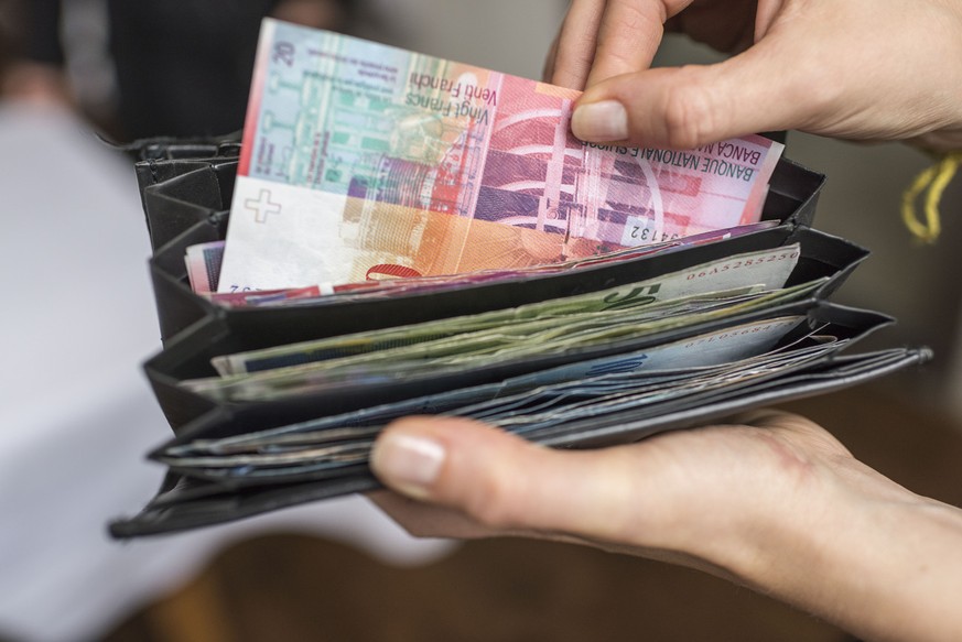 A waitress takes a one twenty Swiss franc bill out of a her wallet, photographed in Zurich, Switzerland, on September 22, 2015. (KEYSTONE/Christian Beutler)

Eine Serviceangestellte entnimmt eine Zwan ...