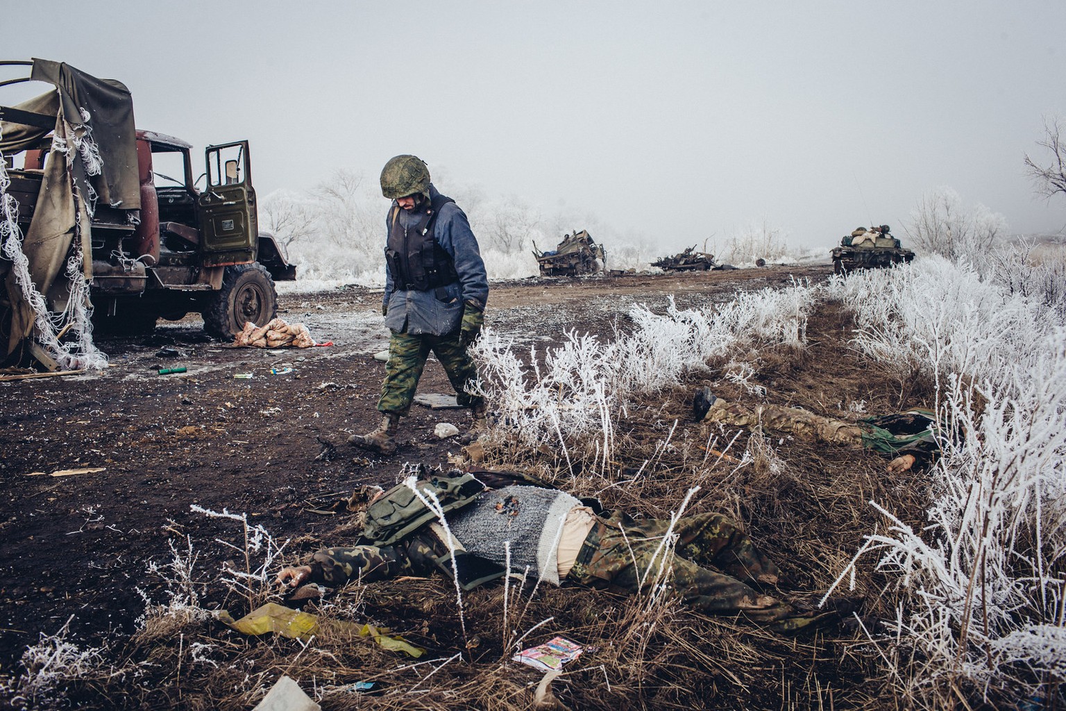 Mit gesenktem Kopf geht ein prorussischer Soldat an seinen getöteten Kameraden vorbei.