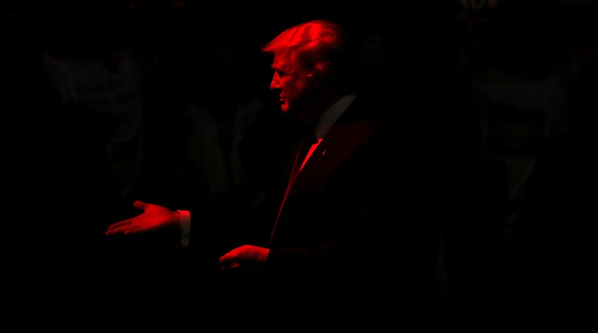 Republican U.S. presidential nominee Donald Trump is bathed in red stage light as he arrives to rally with supporters at an arena in Manchester, New Hampshire, U.S. November 7, 2016. REUTERS/Jonathan  ...
