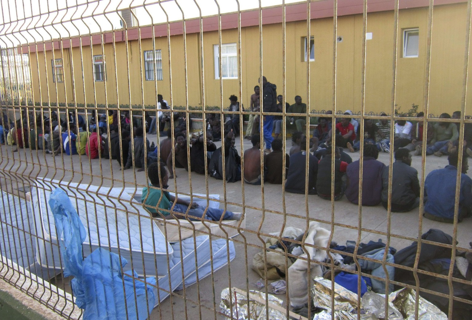 epa04103480 Some of 214 immigrants rest after entering Melilla, a Spanish enclave in northern Africa, during a massive assault against the border, 28 February 2014. More than 200 immigrants have been  ...