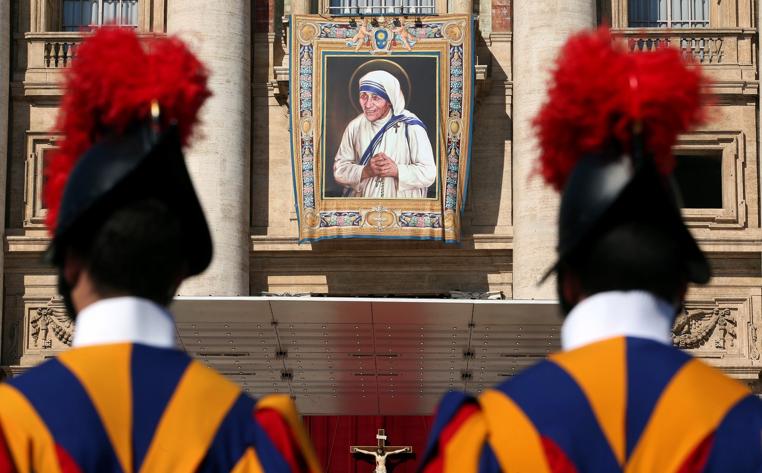 Swiss Guards stand in front of a tapestry depicting Mother Teresa of Calcutta before a mass, celebrated by Pope Francis, for her canonisation in Saint Peter&#039;s Square at the Vatican September 4, 2 ...