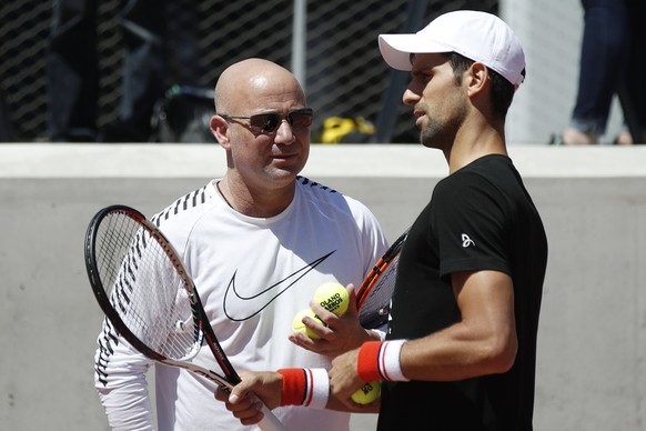 epa05989126 Novak Djokovic (R) of Serbia talks with his new coach Andre Agassi (L) of US during a training session few days ahead of the French Open tennis tournament at Roland Garros in Paris, France ...