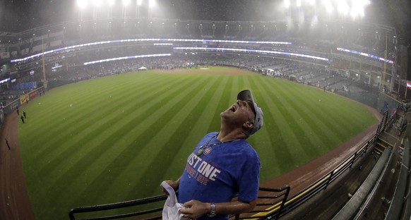 A Chicago Cubs fan catches rain drops in his month after Game 7 of the Major League Baseball World Series against the Cleveland Indians Thursday, Nov. 3, 2016, in Cleveland. The Cubs won 8-7 in 10 inn ...