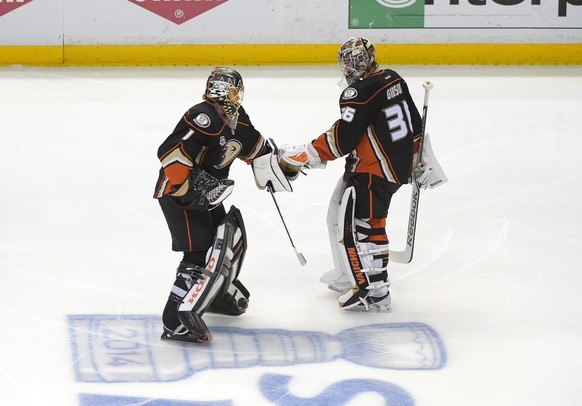 Anaheim Ducks goalie John Gibson, right, leaves the ice as goalie Jonas Hiller, of Switzerland, skates on as the Ducks change goalies during the second period in Game 7 of an NHL hockey second-round S ...