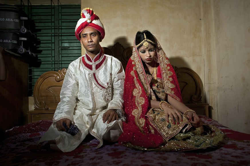 MANIKGANJ, BANGLADESH - AUGUST 20: 32 year old Mohammad Hasamur Rahman poses for photographs with his new bride, 15 year old Nasoin Akhter, August 20, 2015 in Manikganj, Bangladesh. In June of this ye ...